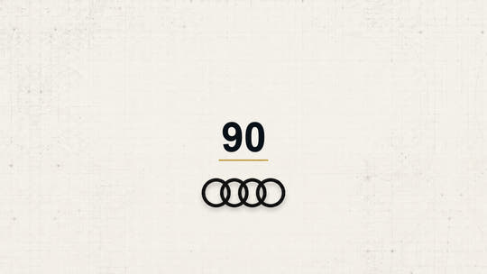 Audi 90 model name with Audi logo on a pale technical background