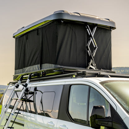 Roof top tent attached to a vehicle with a scenic background