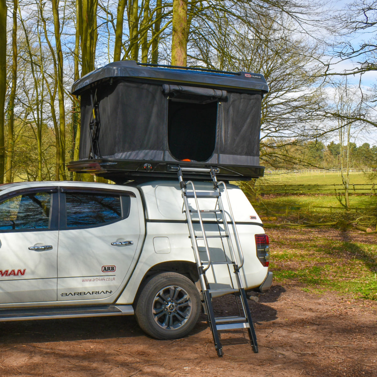 White SUV with a rooftop tent in a natural setting