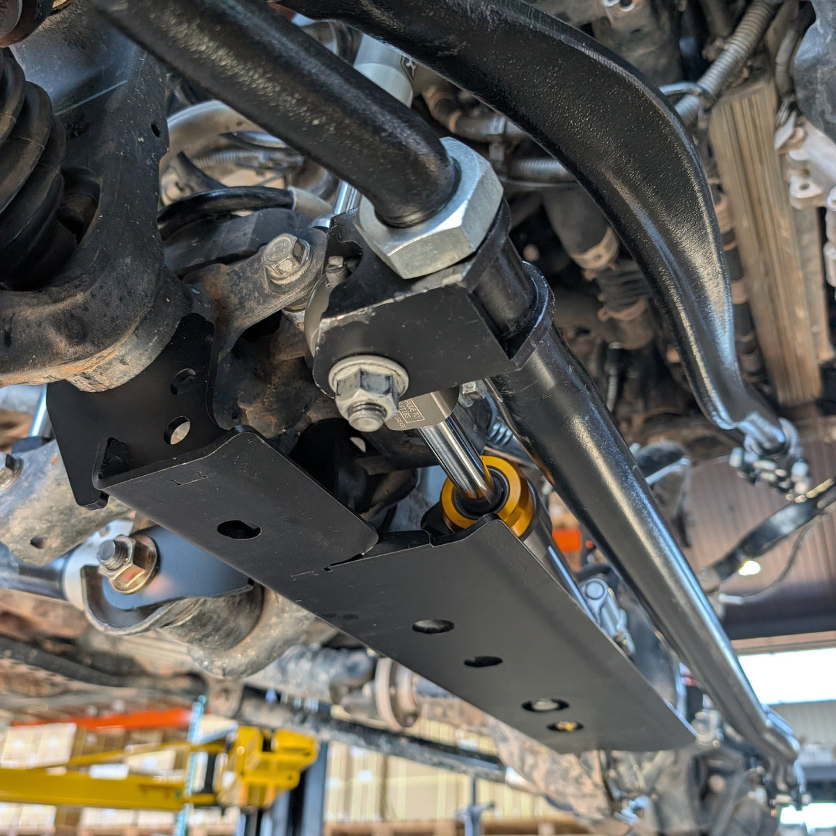 Close-up of the APEX Rock Jock mounting bracket installed on the tie rod clamp
