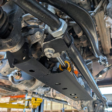 Close-up of the APEX Rock Jock mounting bracket installed on the tie rod clamp